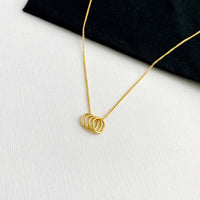 Gold necklace with four circles to represent 40 years and 4 decades for a 40th birthday. KookyTwo.