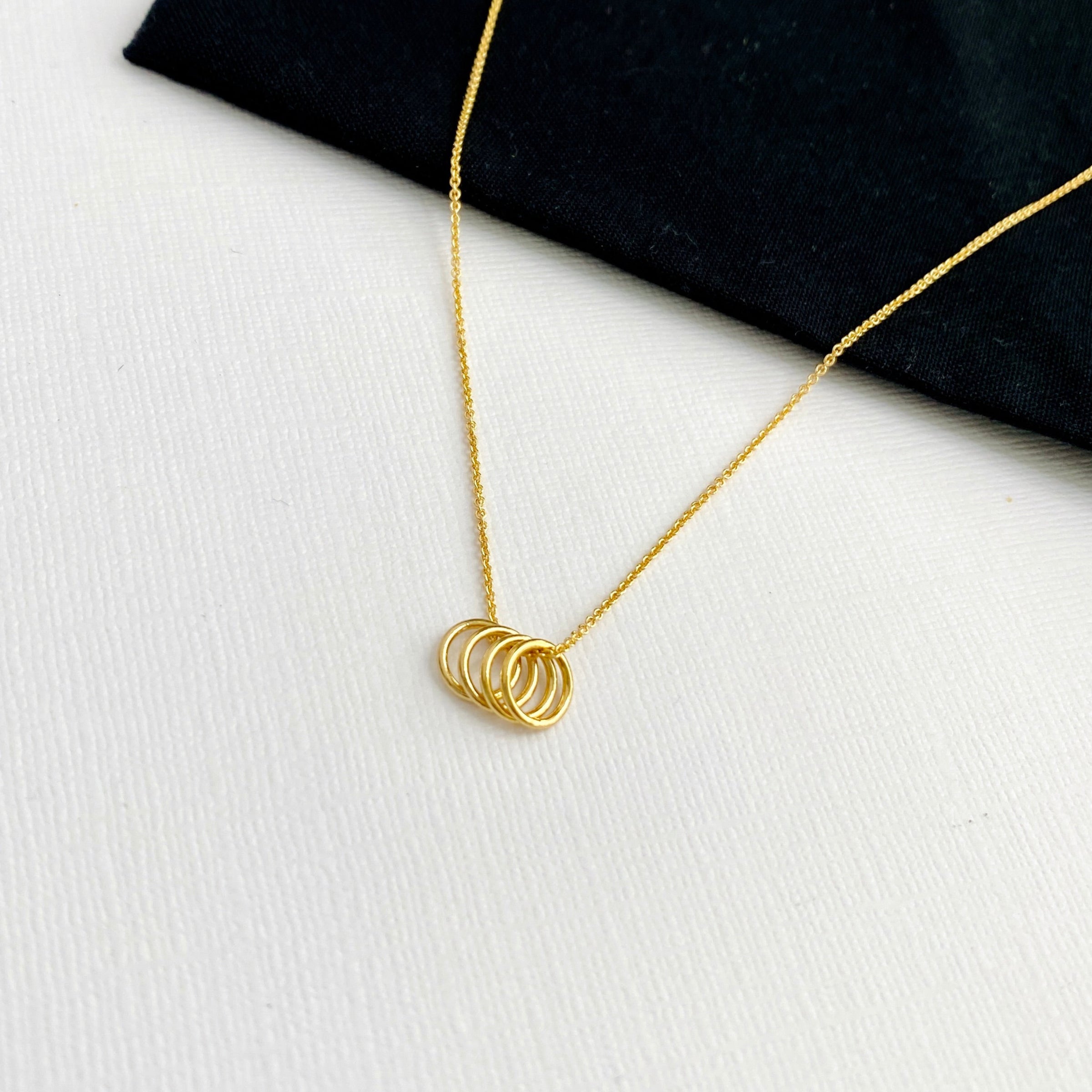 Gold necklace with four circles to represent 40 years and 4 decades for a 40th birthday. KookyTwo.