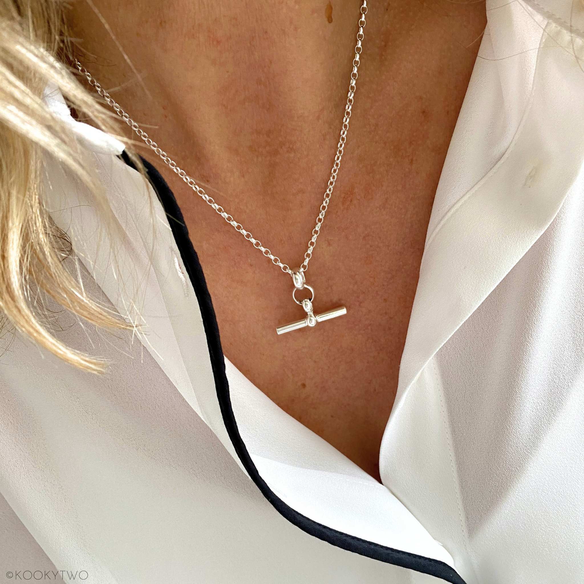 Chunky T bar charm necklace worn on model, showing how it sits beautifully on the neckline.