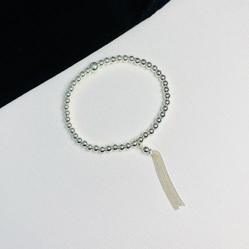 Silver bead bracelet with tassel charm.