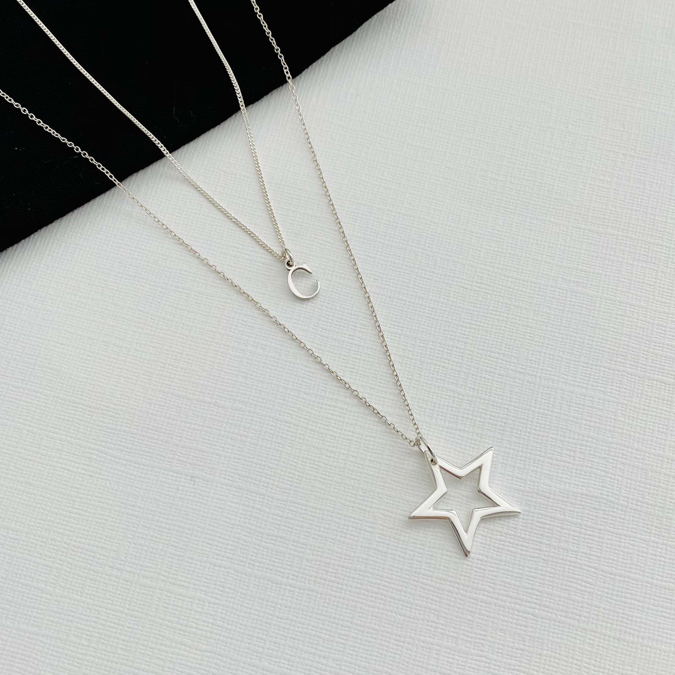 Sterling silver necklace layering set, with dainty silver initial necklace and silver star charm necklace, in two different lengths. KookyTwo.