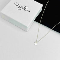 Silver necklace with mini heart charm.