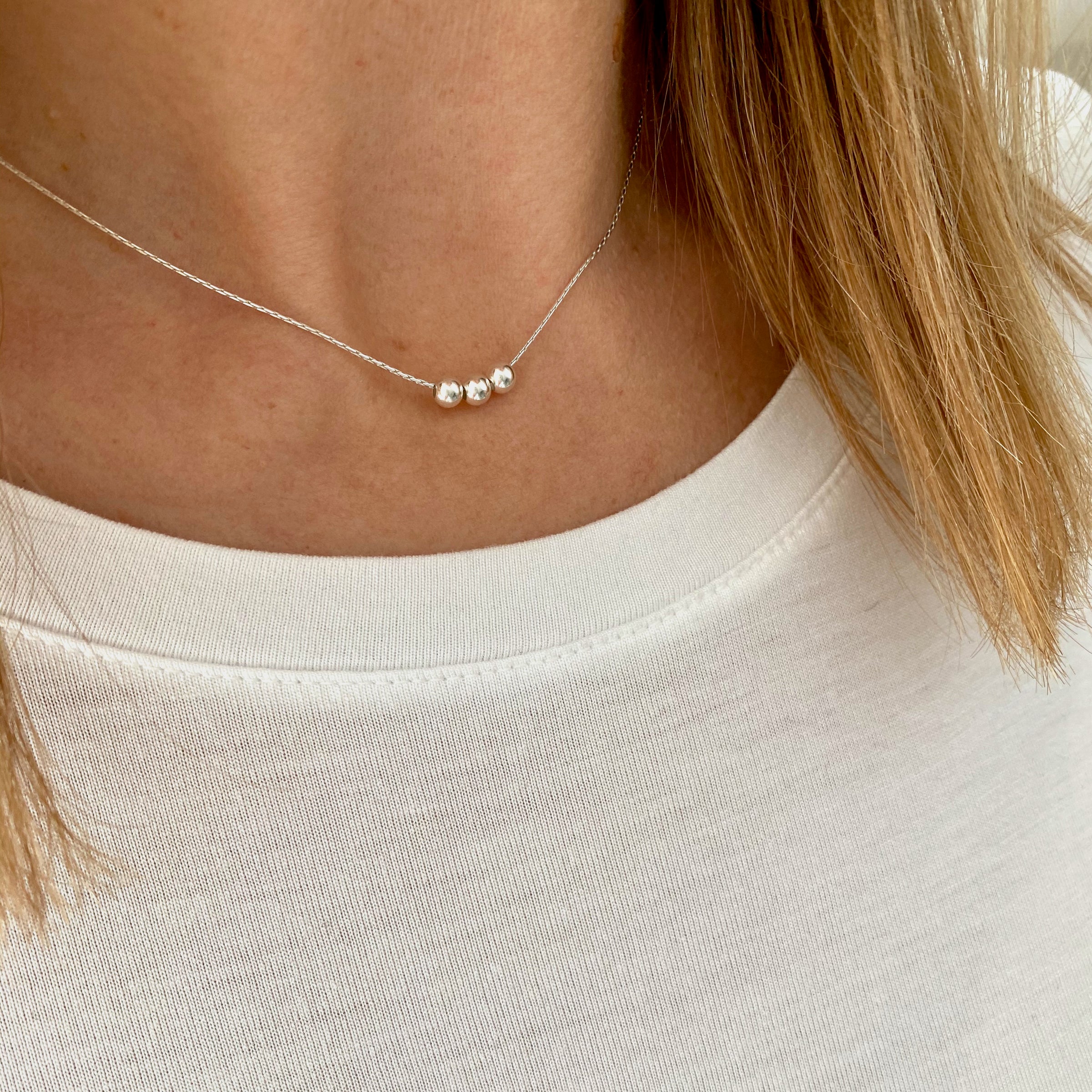 Contemporary sterling silver necklace with three shiny silver beads. Kooky Two.