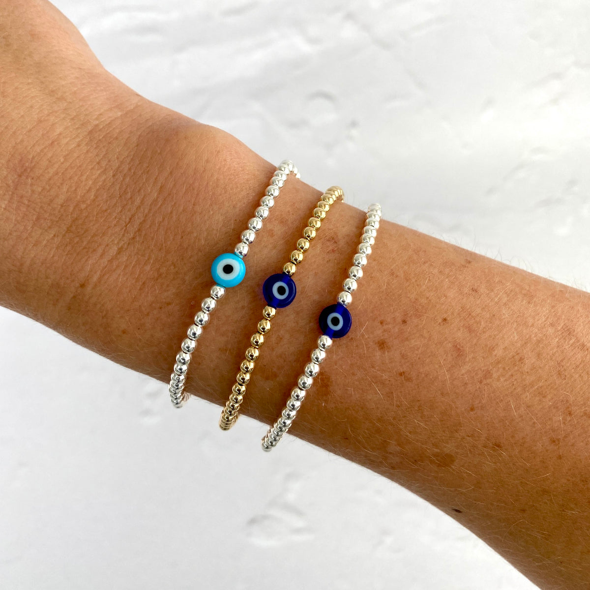 Silver and gold bead bracelets with pretty blue evil bead or turquoise evil eye bead. Handmade on strong jewellery elastic with sterling silver beads or 14k gold filled beads.