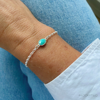 Close-up of a dainty amazonite bracelet with a sterling silver chain, showcasing the calming blue-green hues of this soothing gemstone.