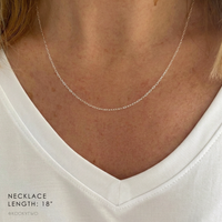 A close-up of a delicate sterling silver necklace worn on a model's neck, paired with a white V-neck top. Text in the bottom-left corner reads 'NECKLACE LENGTH: 18"' and '@KOOKYTWO'.