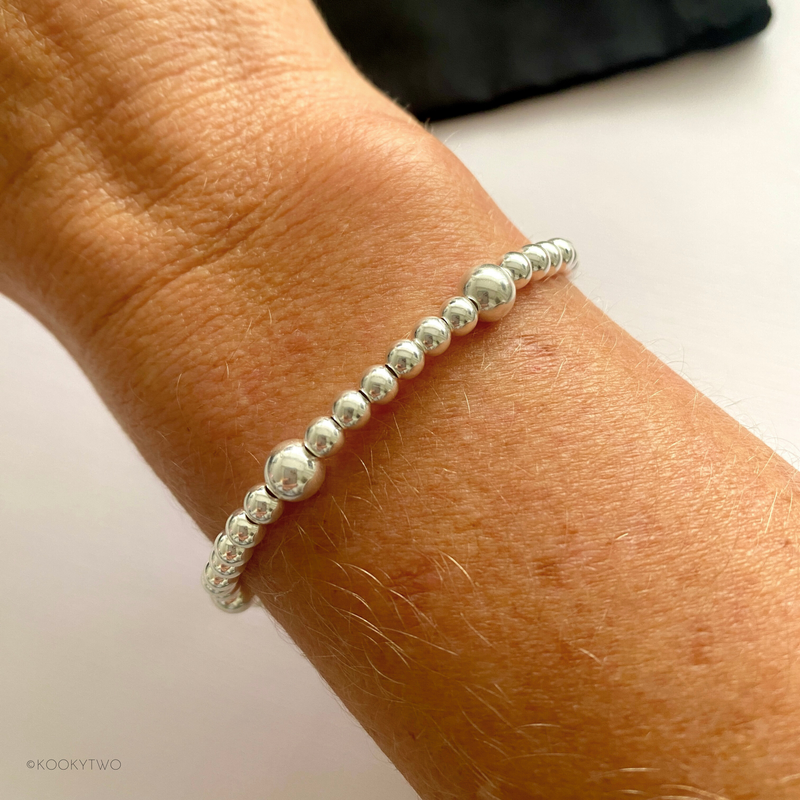 A lightweight and stylish sterling silver bead bracelet worn on a wrist, perfect for bracelet stacking or wearing solo. KookyTwo.