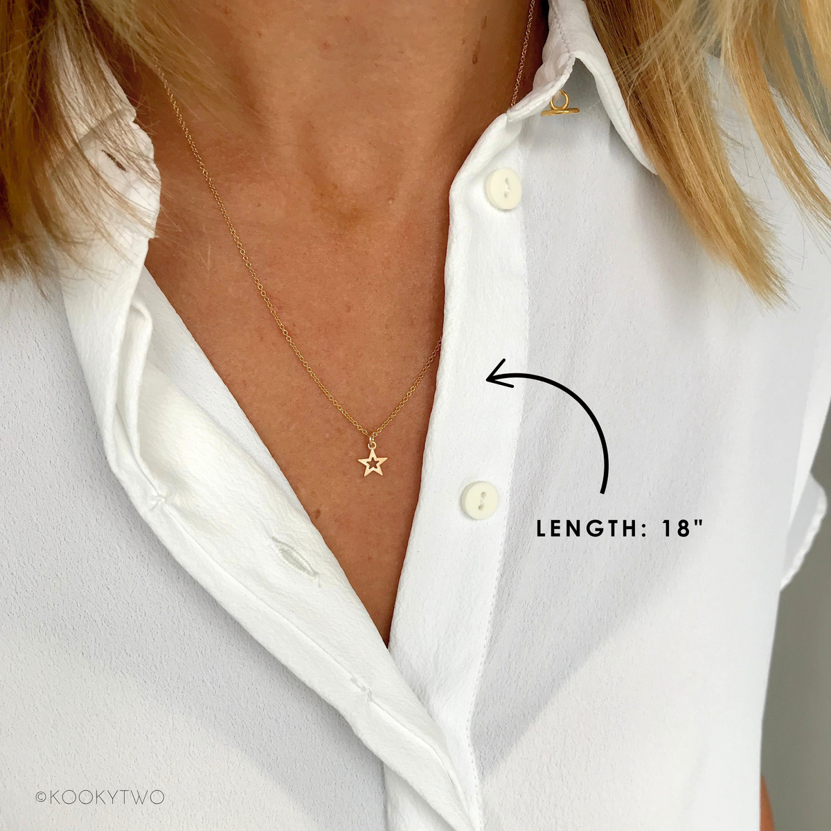 Gold star necklace on a person wearing a white shirt, with a label indicating the length of 18"