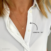 Gold star necklace on a person wearing a white shirt, with a label indicating the length of 18"