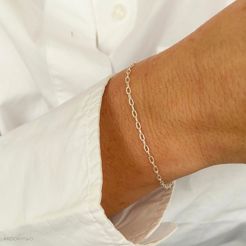 Close-up of a dainty sterling silver bracelet with a fine chain, showcasing its sleek and timeless design. KookyTwo.