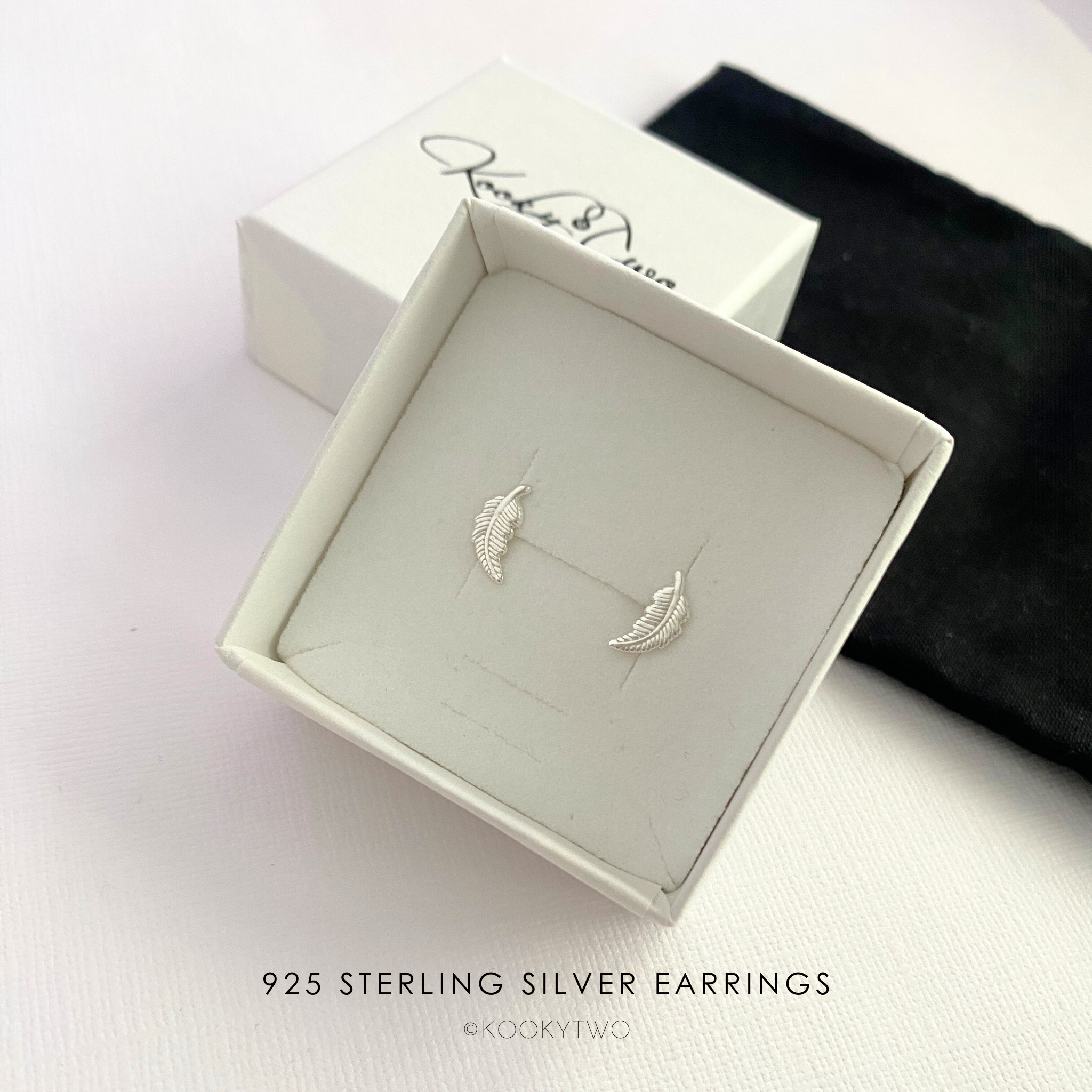 925 Sterling Silver Feather Stud Earrings in a box with KookyTwo branding.