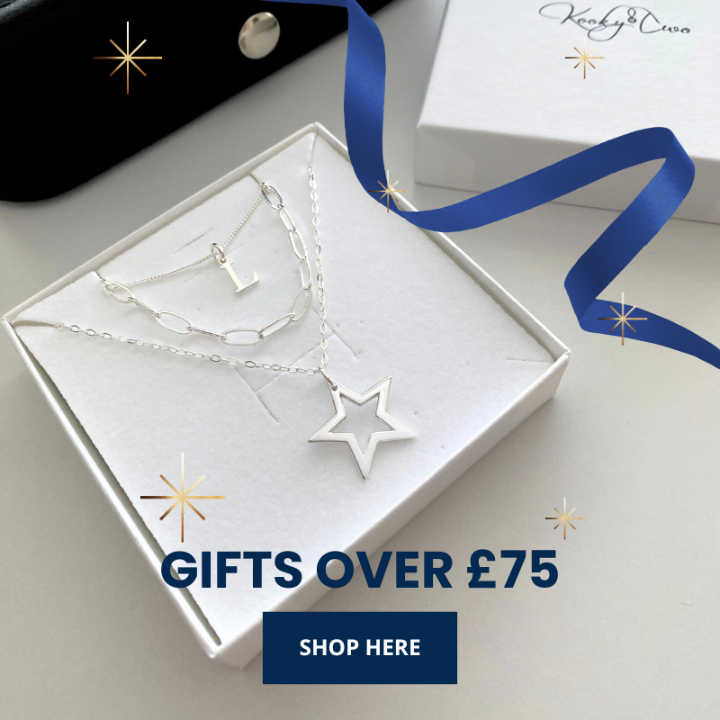 Silver initial necklace set, with paperclip chain necklace and silver star pendant necklace in a white box, blue ribbon, and 'KookyTwo' branding.