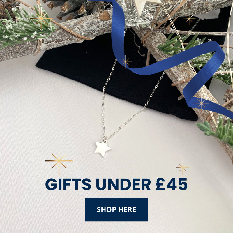 Star-shaped charm necklace on a white surface with decorative elements and text promoting Christmas gifts under £45.