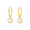 Gold hoop earrings with sparkly crystal hanging charms. KookyTwo.