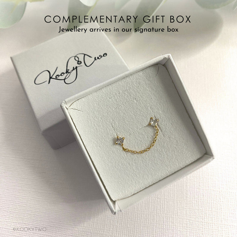 Box with gold and crystal ear jacket with chain between two crystal stones. Branding on box is KookyTwo.