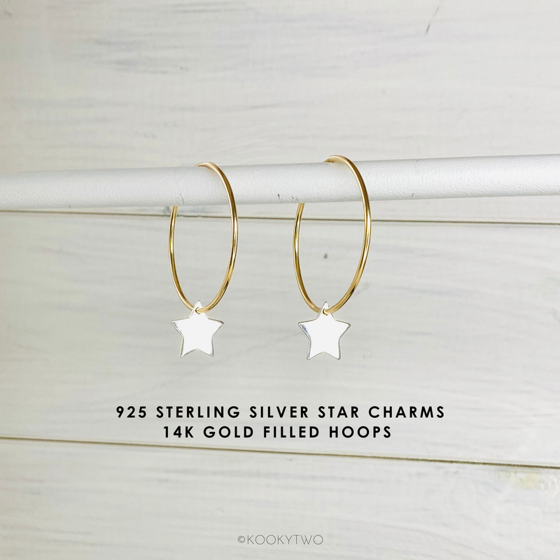 Gold hoop earrings with star charms on a light wooden background