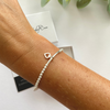 Elegant sterling silver bead bracelet with a delicate heart charm, perfect for everyday wear or gifting. KookyTwo.