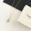 14k gold filled necklace with a larimar gemstone pendant on a white surface next to a jewellery gift box.