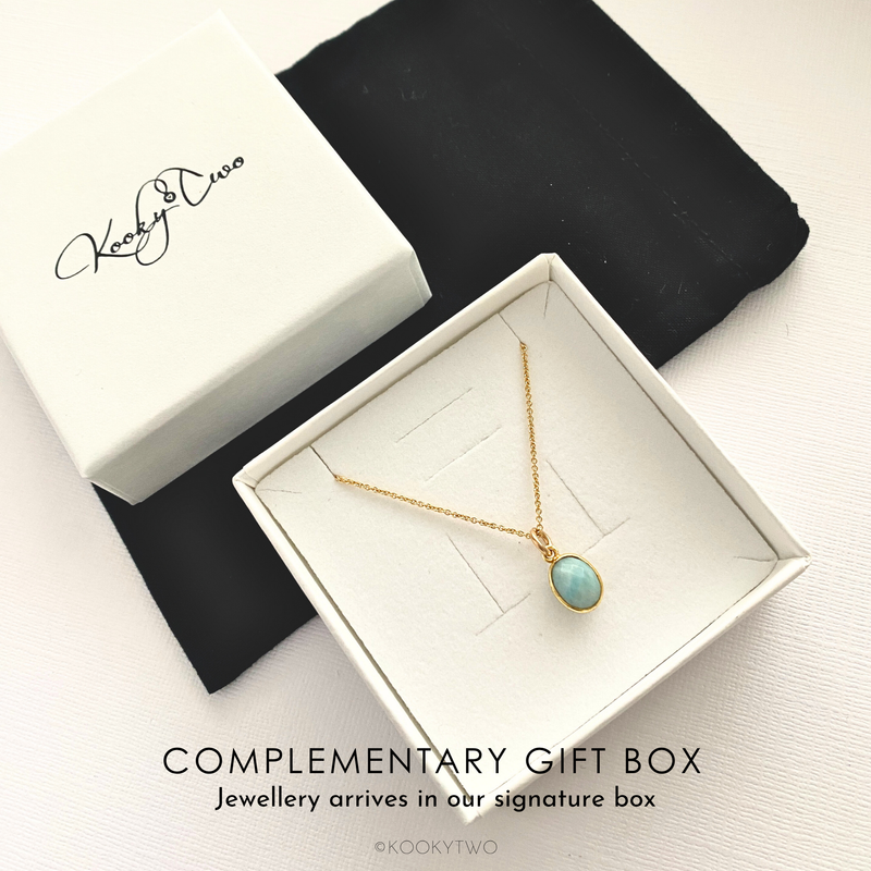 Jewellery box with a gold necklace featuring a blue pendant, branded 'KookyTwo'.