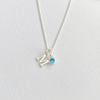 A delicate sterling silver initial necklace, with a blue crystal. Custom initial necklace in a minimalist, elegant style, perfect for everyday wear. KookyTwo.