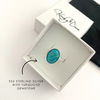 Turquoise gemstone silver ring in a white gift box.