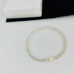Sterling silver stacking bracelet with silver beads and pearl bead. KookyTwo.