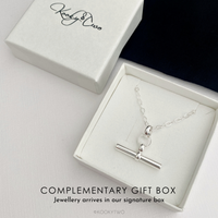 A silver pendant necklace displayed in an open white gift box, and the text 'COMPLEMENTARY GIFT BOX' on a light background. The signature 'KooktyTwo' is visible on the closed box.