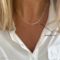 Paperclip chain necklace in sterling silver on a person with a white shirt, showing the length measurement at 16" chain length.