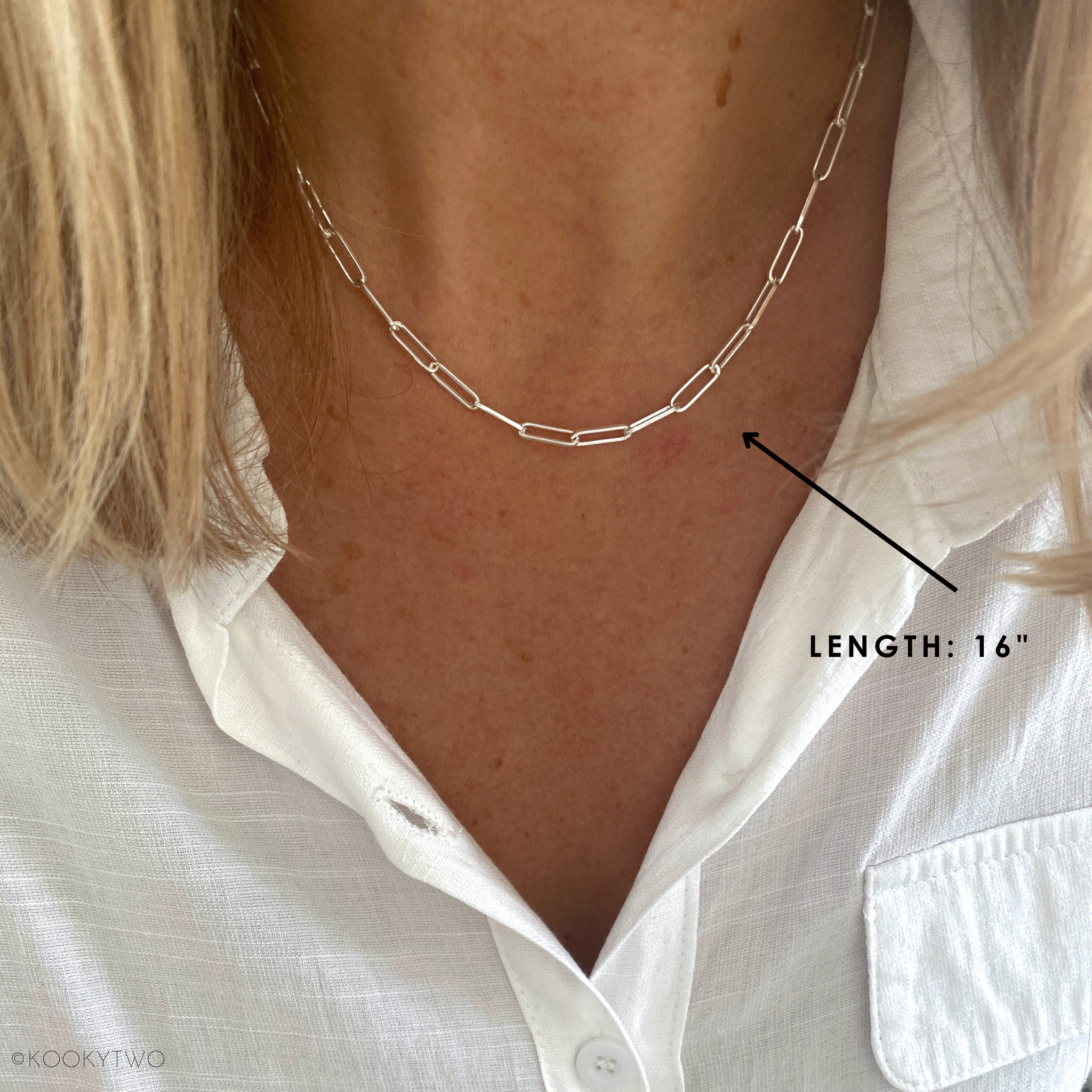 Paperclip chain necklace in sterling silver on a person with a white shirt, showing the length measurement at 16" chain length.
