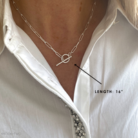 Sterling Silver T bar necklace on a person wearing a white shirt, with a  label indicating necklace length of 16" chain.