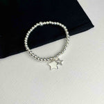 Sterling silver bead star bracelet with two star charms. KookyTwo.
