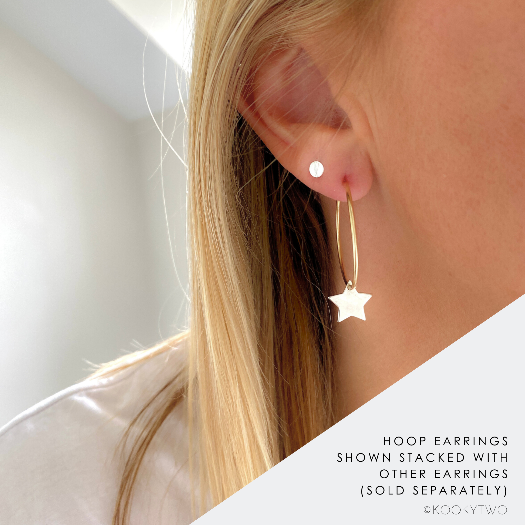 Star-shaped earring worn by a person with blonde hair, on a neutral background.