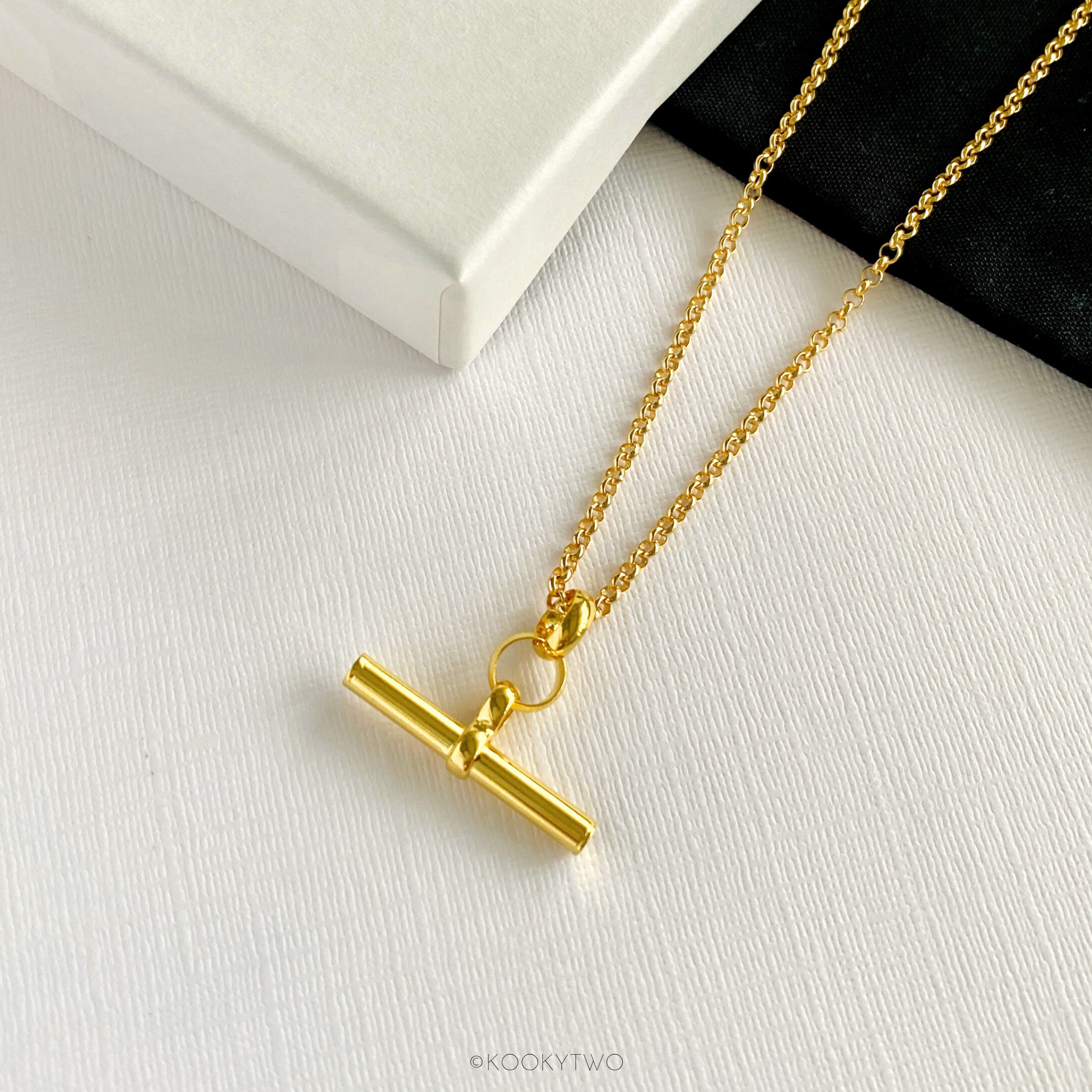 On trend T bar necklace in gold on background to show the high-quality materials and contemporary design. KookyTwo.
