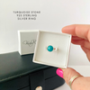 Turquoise stone 925 sterling silver ring in a box held by a hand.