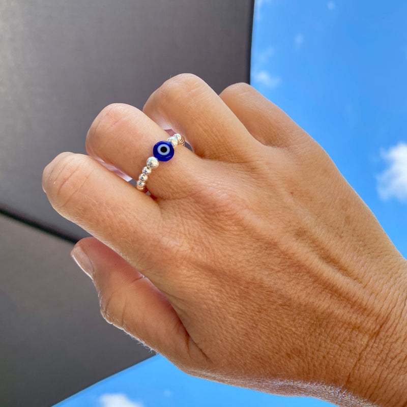 Silver bead ring with blue bead with evil eye design.