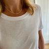 Lady wearing white top with silver rolo necklace.