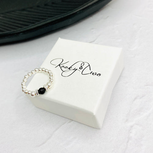Black onyx jewellery ring with black onyx gemstone alongside shiny silver beads. KookyTwo