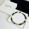 Snowflake obsidian bracelet with gold beads arrives in a white gift box.