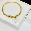 Silver star pendant on gold bead bracelet. Hand beaded bracelet jewellery design made in the UK.