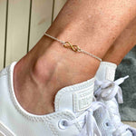 Gold infinity charm anklet in sterling silver with adjustable chain.