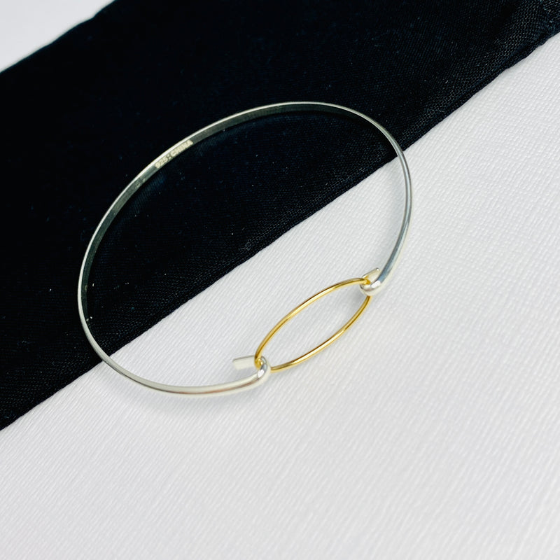 Ladies bangle in silver and gold. Bracelet for women with gold eternity charm.