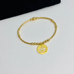 Gold beaded bracelet with lotus flower yoga charm