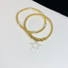 Mixed metal bracelet stack with silver star charm. Hand beaded gold bracelets with silver charm and silver beads.