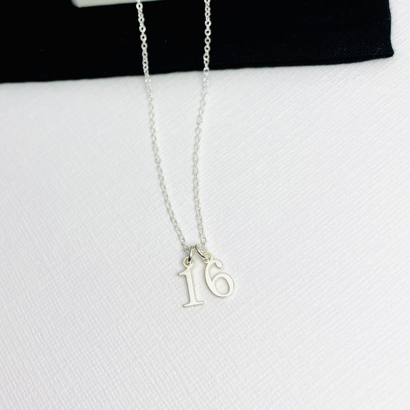 Delicate sterling silver necklace with silver number charms. Kooky Two.