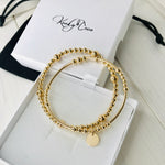 Gold stacking bracelet set with a gold disc. KookyTwo