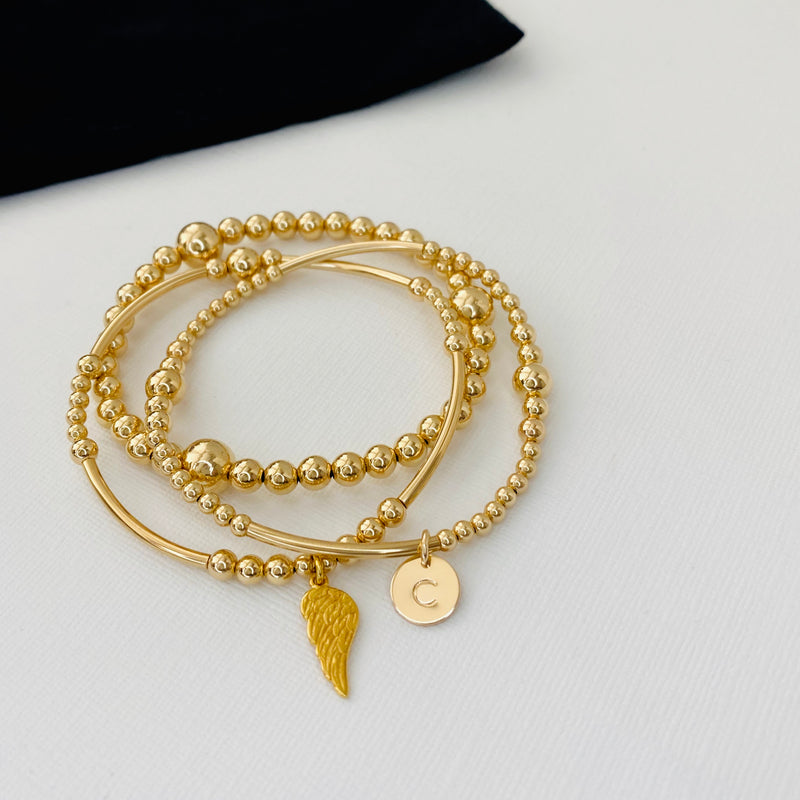 Personalised stacking bracelet set with three gold bracelets. Perfect stacking bracelet gift set for her with an alphabet charm.