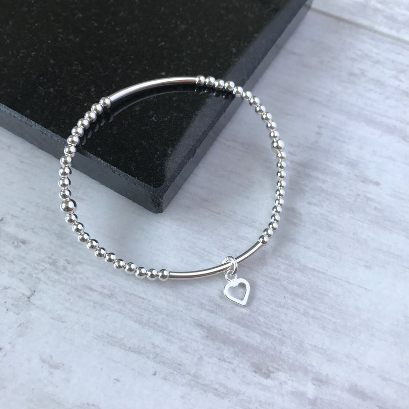 Minimalist sterling silver bracelet with polished beads and a heart charm, ideal for stacked bracelet look or wearing solo. KookyTwo