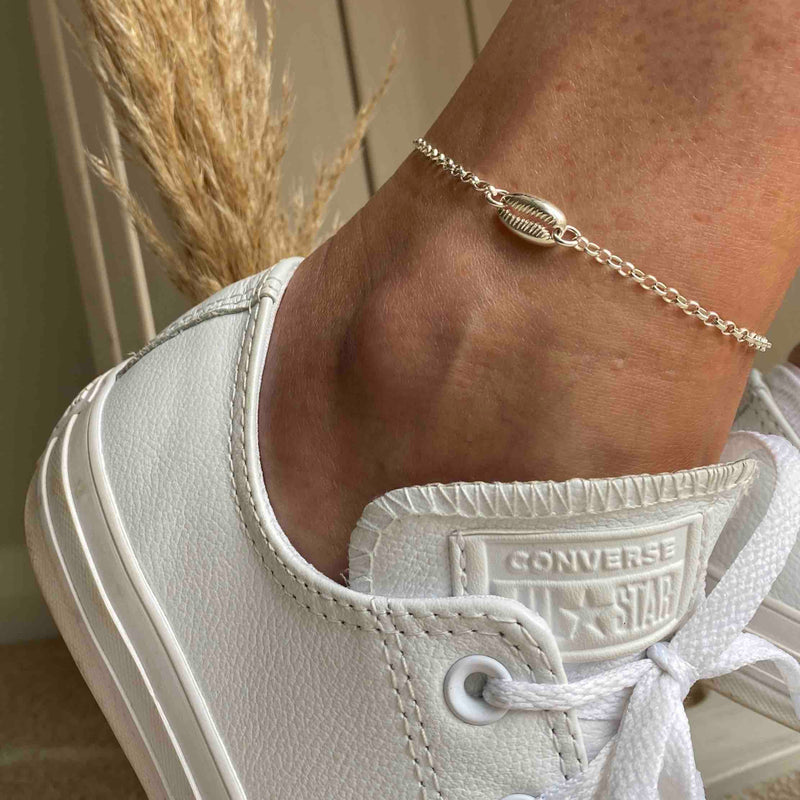 Anklet with shell charm in sterling silver. Adjustable anklet with cowrie shell charm.