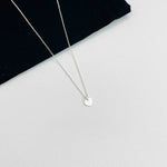 Minimalist necklace with silver heart charm.