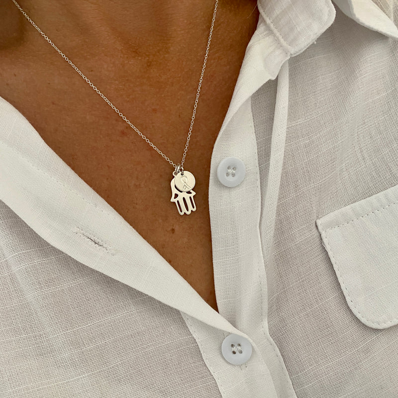 The Lynn Hamsa and Ribbon Necklace raising funds for cancer research. Necklace with Hamsa Hand Charm and Ribbon Disc Charm in Sterling Silver